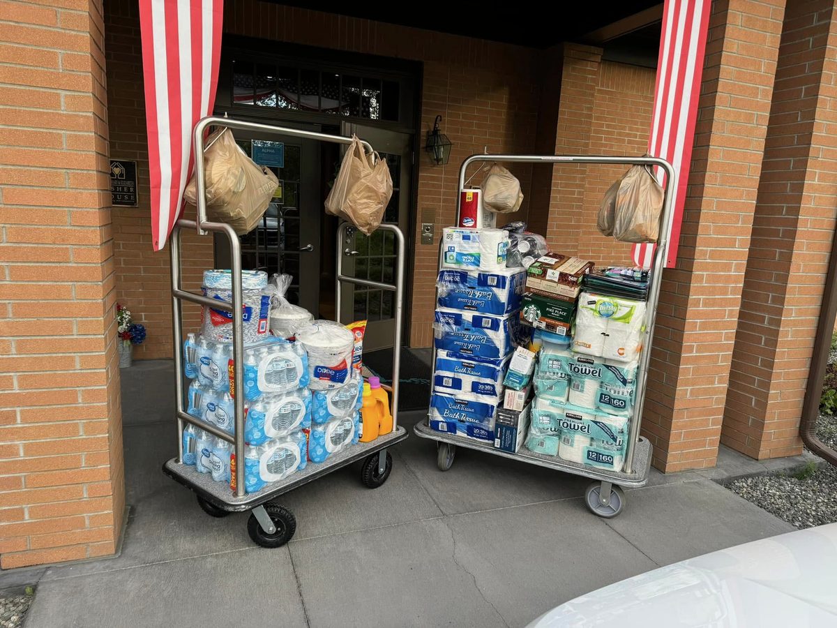 Two carts loaded with donated paper goods and supplies at the Fisher House entrance