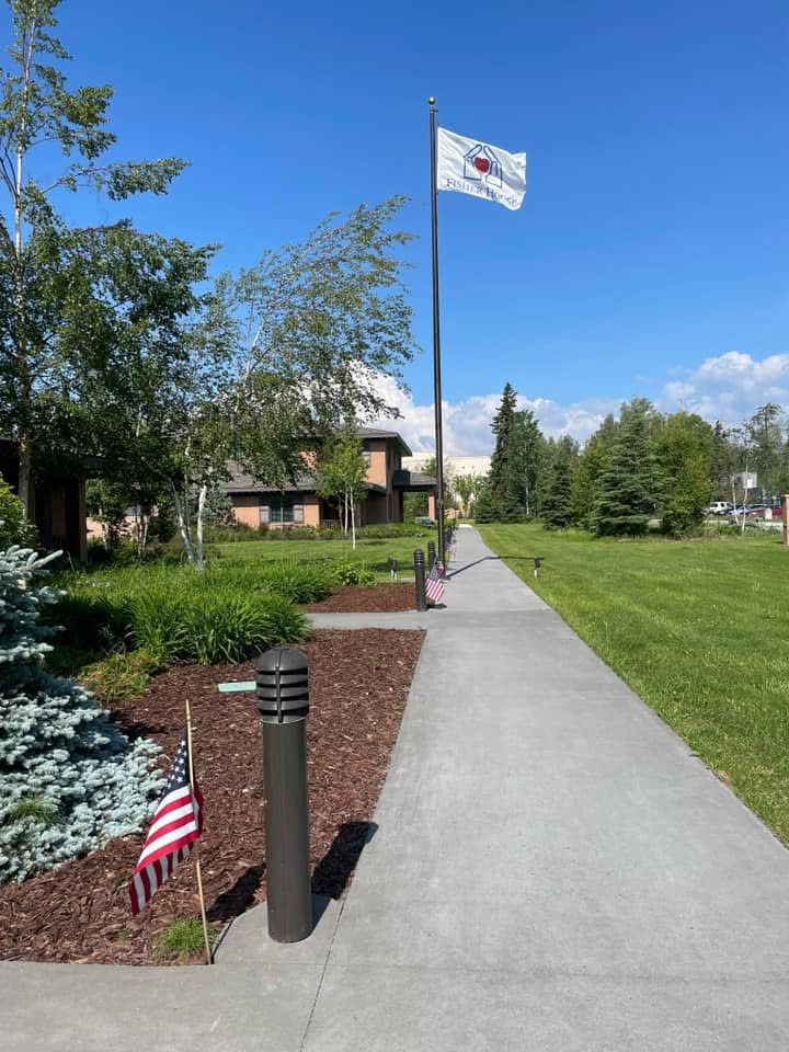 The walkway to the Fisher House with the flag flying on a summer day