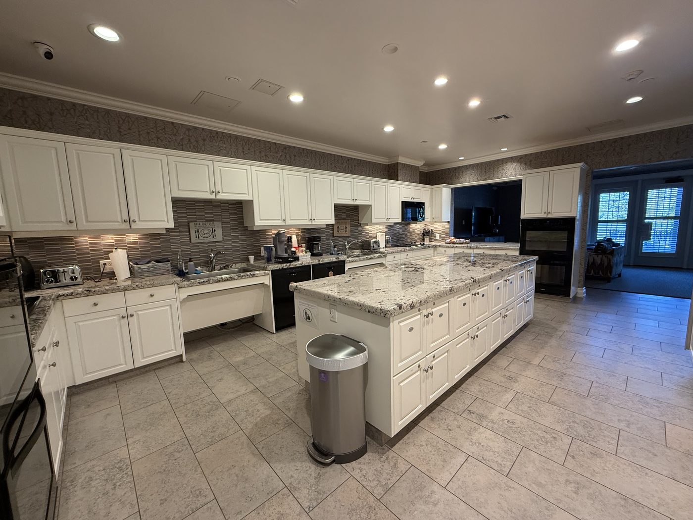 The shared gourmet kitchen with a large granite island and double ovens