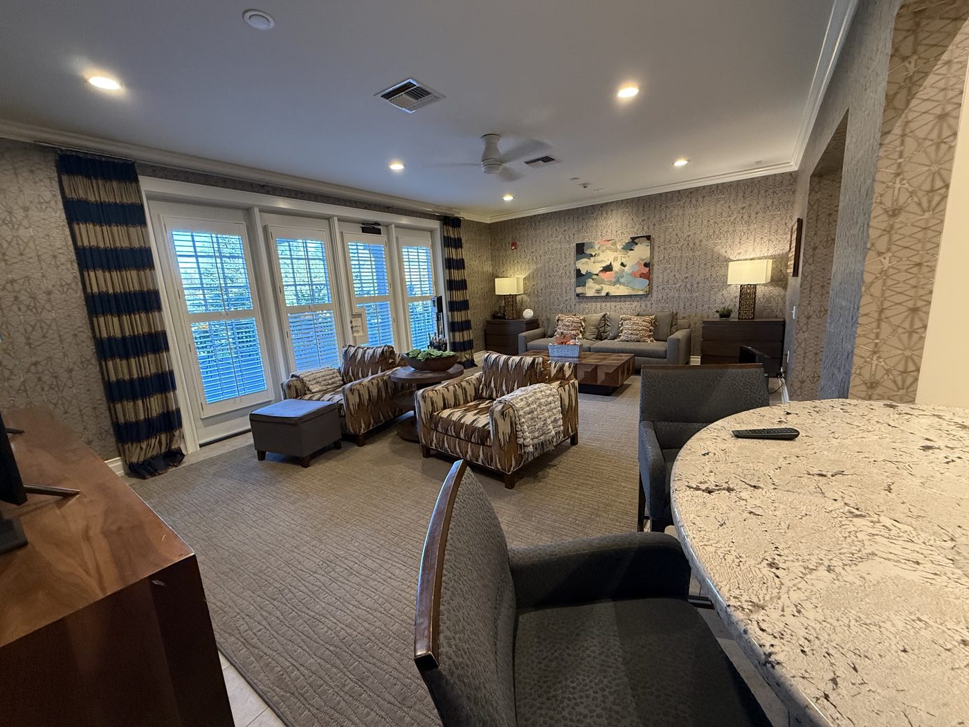 The living room at the Alaska Fisher House, with armchairs, a long table, and windows onto the yard