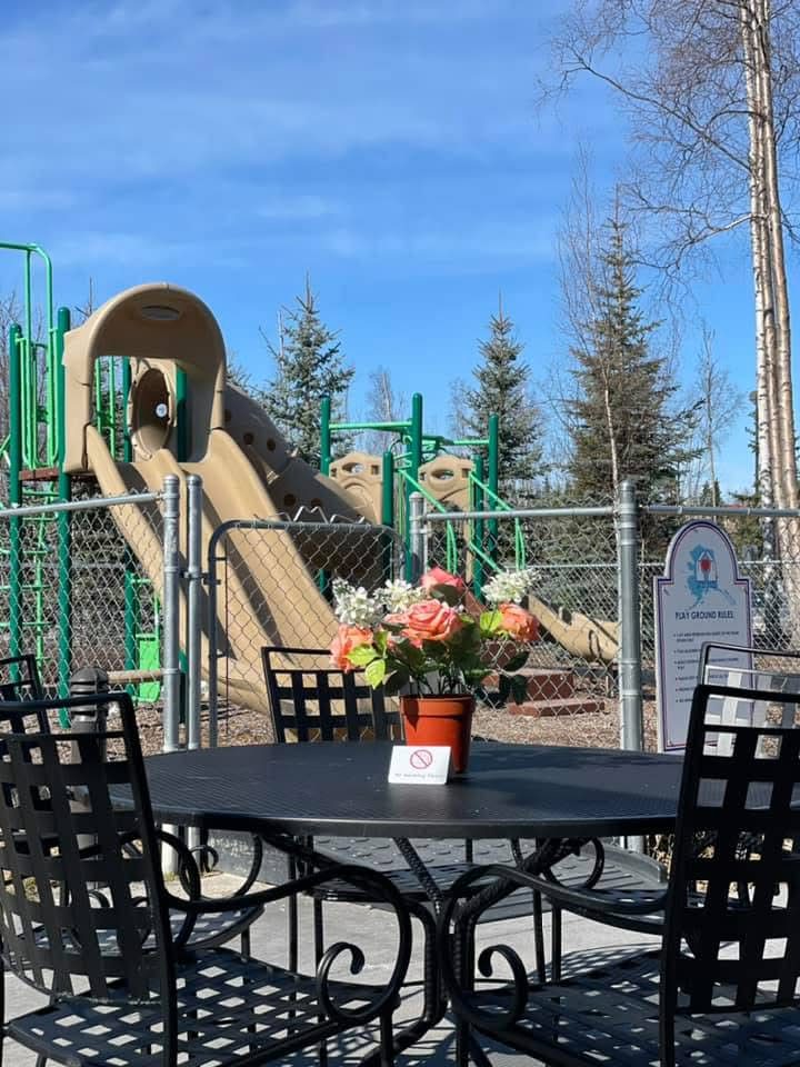 The outdoor patio table with the playground behind it