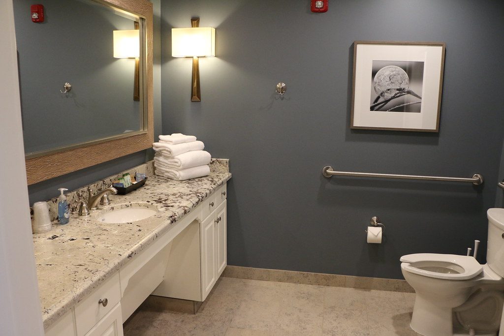 A private wheelchair-accessible bathroom with grab bars and fresh towels