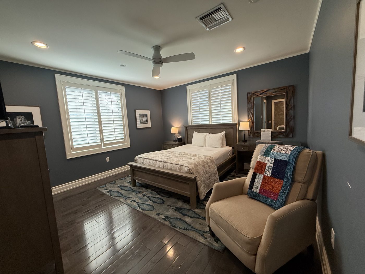 A private guest suite with a full bed, armchair, and quilt