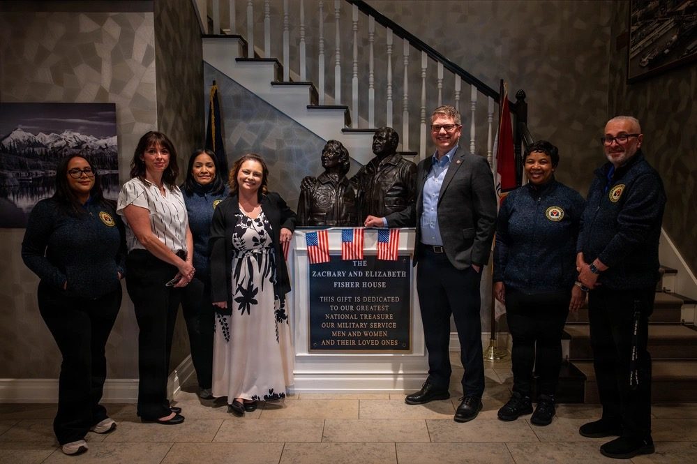 Supporters gathered around the Zachary and Elizabeth Fisher dedication plaque inside the house